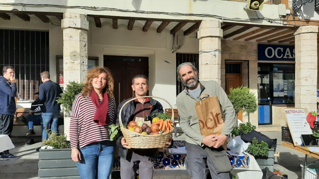Personas con una cesta de productos locales en un encuentro en Guadalajara